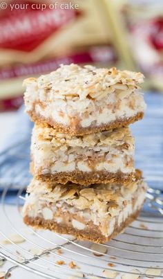 three dessert bars stacked on top of each other with coconut flakes all over them