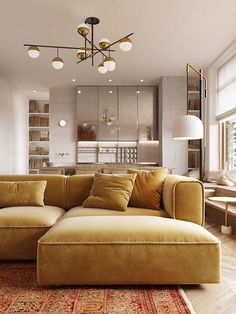 a living room filled with furniture and a large window covered in light colored pillows on top of a wooden floor