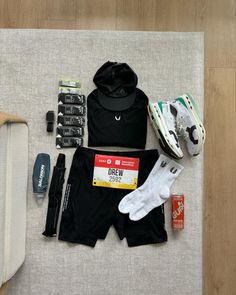 the contents of a running outfit laid out on a mat next to shoes, water bottle and other items