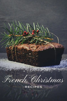 a piece of chocolate cake sitting on top of a table next to a pine tree