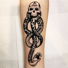 a tattoo on the leg of a person with a skull and snake in its hand