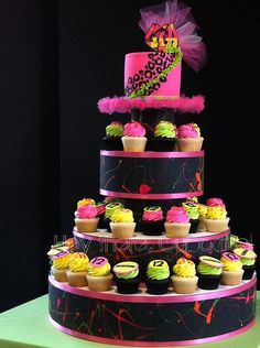 a three tiered cake with cupcakes on it