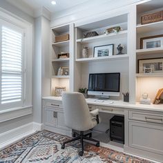 a home office with built - in shelving, desk and computer monitor on it