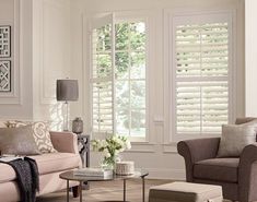 a living room filled with furniture and windows covered in white shuttered glass coverings