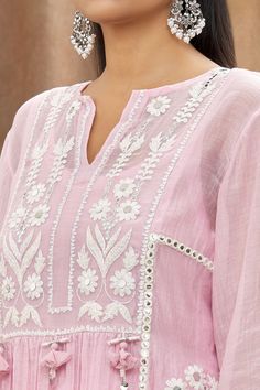 Pink mulmul chanderi kurta with white thread embroidery, embellishment of mirrors, shells, handmade tassels and side slits. Paired with a cotton embroidered Pakistani salwar, lehriya crinkled dupatta and sleeveless slip.
Component: 4
Pattern: Embellishment and Embroidered
Type Of Work: Mirror and Thread Work
Neckline: Notched Round Neck
Sleeve Type: Batwing Sleeves
Fabric: Kurta: Mulmul Chanderi, Cotton
Color: Pink
Other Details: 
Tassels details on kurta)
Gota work stripes on dupatta
Pom-Poms t Mulmul Kurta, Cotton Thread Embroidery, Pink Kurta, Trendy Outfits Indian, Pakistani Salwar, Hand Embroidery Dress, Embroidery On Kurtis, Gota Work