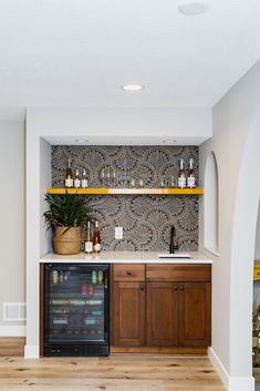 a kitchen with wooden cabinets and shelves filled with bottles on top of the cupboards