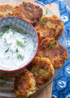 some food is in a bowl and on a glass platter next to a blue table cloth