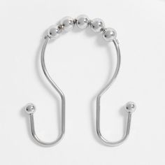 a pair of metal hooks on a white surface