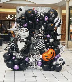 a halloween display in the middle of a shopping mall filled with black and white balloons