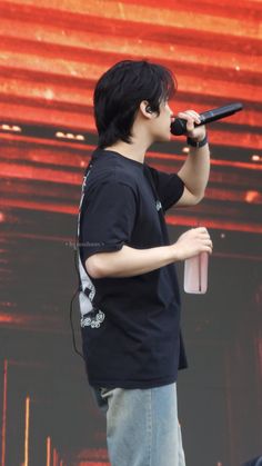 a male in a black shirt is holding a microphone