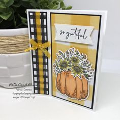 a close up of a card on a table with a potted plant in the background