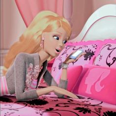 a barbie doll sitting on top of a bed holding a cell phone in her hand