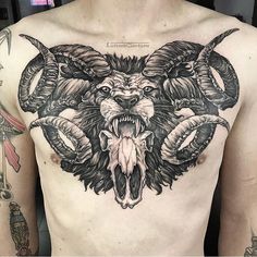 a man with tattoos on his chest has an animal head and two horns attached to it