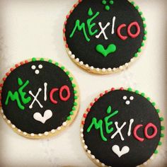 three decorated cookies with mexican writing on them