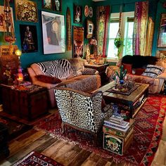 a living room filled with lots of furniture and pictures on the wall above it's windows