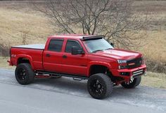 a red truck is parked on the side of the road