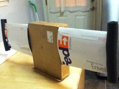 an open cardboard box sitting on top of a wooden table next to a metal refrigerator