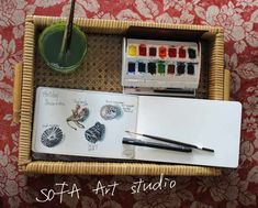 a wicker tray with art supplies on it