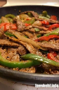 beef and peppers stir fry in a skillet on the stove top, ready to be cooked