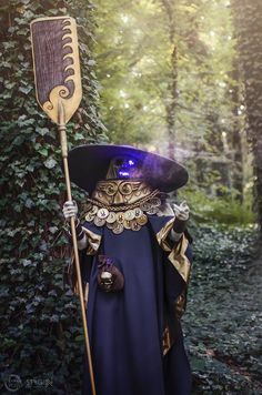 a wizard in the woods holding a broom and wearing a purple outfit with gold accents