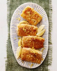 fish fillets on a plate with lemon wedges