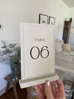 a person holding up a table number in their hand