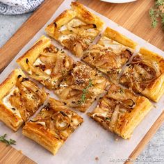 several square pieces of food sitting on top of a cutting board