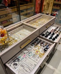 an assortment of jewelry is displayed in a display case at a jewelery shop,