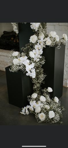 white flowers are arranged in black vases