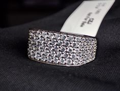 a close up of a ring with diamonds on it and a price tag in the background