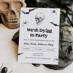 there is a halloween party card on the table with bats and skulls in the background