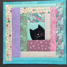 a patchwork quilt with a black cat on it