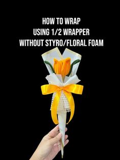 someone is holding up a paper flower with yellow ribbon and the words how to wrap using 1 / 2 wrapper without styrofoal floral foam