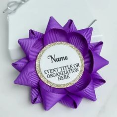 a purple bow with the name event title or organization here written on it in gold glitters