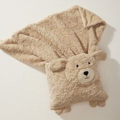 a brown teddy bear laying on top of a blanket