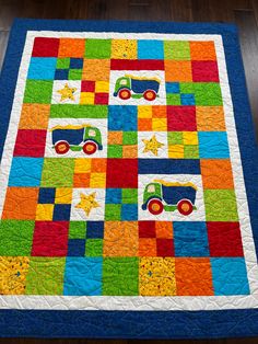 a colorful quilt with trucks and stars on it