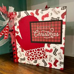 a christmas card with a red apple on it and ribbon attached to the front cover