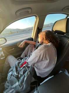 a woman sitting in the back seat of a car