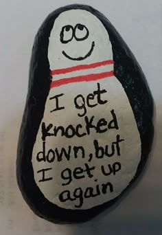 a painted rock that says i get knocked down, but i get up again