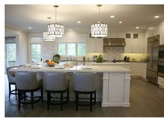 a large kitchen with white cabinets and an island