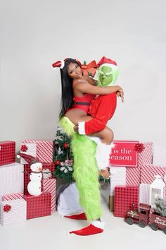 a woman in a santa clause outfit hugging a man dressed as the grinen girl