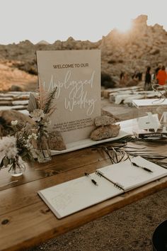 a wooden table topped with lots of white flowers and writing on top of it next to a sign that says welcome to our wedding