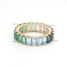 Emerald aquamarine blue topaz emerald cut eternity band ring gold | Natural emerald cut emerald ombre ring gold | Green to blue ombre ring  GEMSTONE DETAILS : ✦ Gemstone : Emerald ✦ Gemstone Type : Natural ✦ Gemstone Size : 5x3 MM ✦ Gemstone Shape : Emerald cut / Octagon cut ✦ Gemstone Weight : 6.90 Carats ✦ Gemstone Grade : AAA METAL DETAILS : ✦ Metal : 14K/18K Gold ✦ Metal Color : Yellow / White / Rose Gold ✦ Setting : Shared Prong Setting ✦ Ring Box : Yes SHIPPING DETAILS : ✦ Shipped via : UPS ✦ Production time : 10-12 days ✦ Delivery time : 7-8 days ✦ Expedited shipping : Available ✦ Expedited shipping service : UPS ✦ Expedited shipping time : 5 days ✦ Expedited shipping cost : 70$ CUSTOMISATION DETAILS : We can customize any piece of fine jewelry. You can simply message us on Etsy or Aquamarine Eternity Ring, Blue Emerald Cut Stackable Jewelry, Emerald Cut Eternity Band, Ombre Rings, Green Aquamarine, Green To Blue, Rainbow Sapphires, Ringe Gold, Rainbow Bracelet