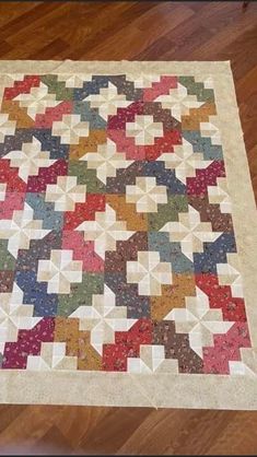 a multicolored quilt is on the floor