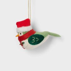 a christmas ornament with a bird wearing a santa hat