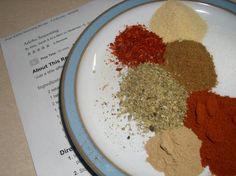 a plate filled with spices on top of a table next to a piece of paper