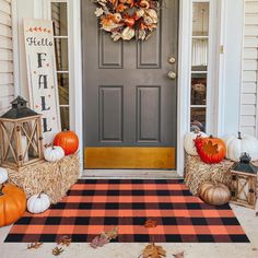 a front door decorated for fall with hay bales, pumpkins and other decorations