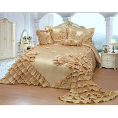 a large bed covered in golden ruffled sheets