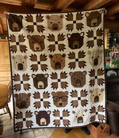 a quilt made to look like bears is on display in a room with wooden floors