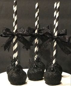 three black cake pops with white and black striped candles